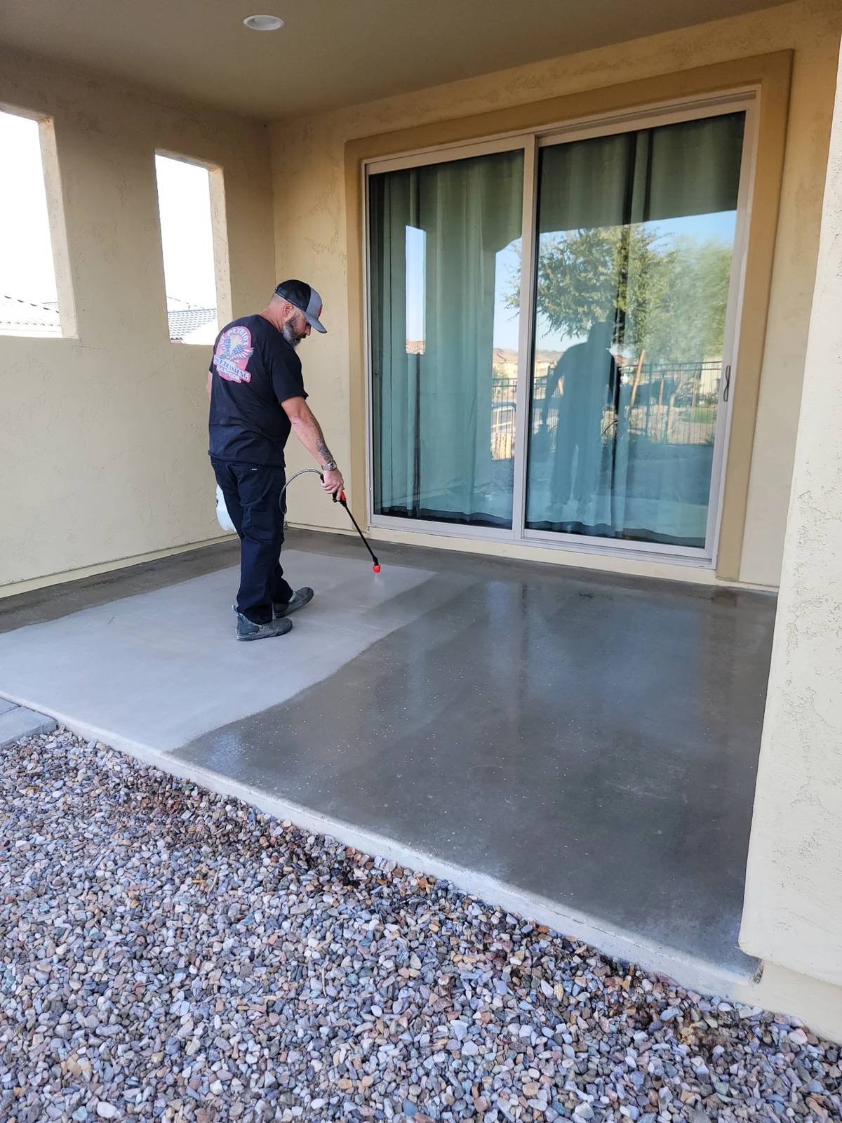 Patriot technician applying penetrating sealer to a concrete patio