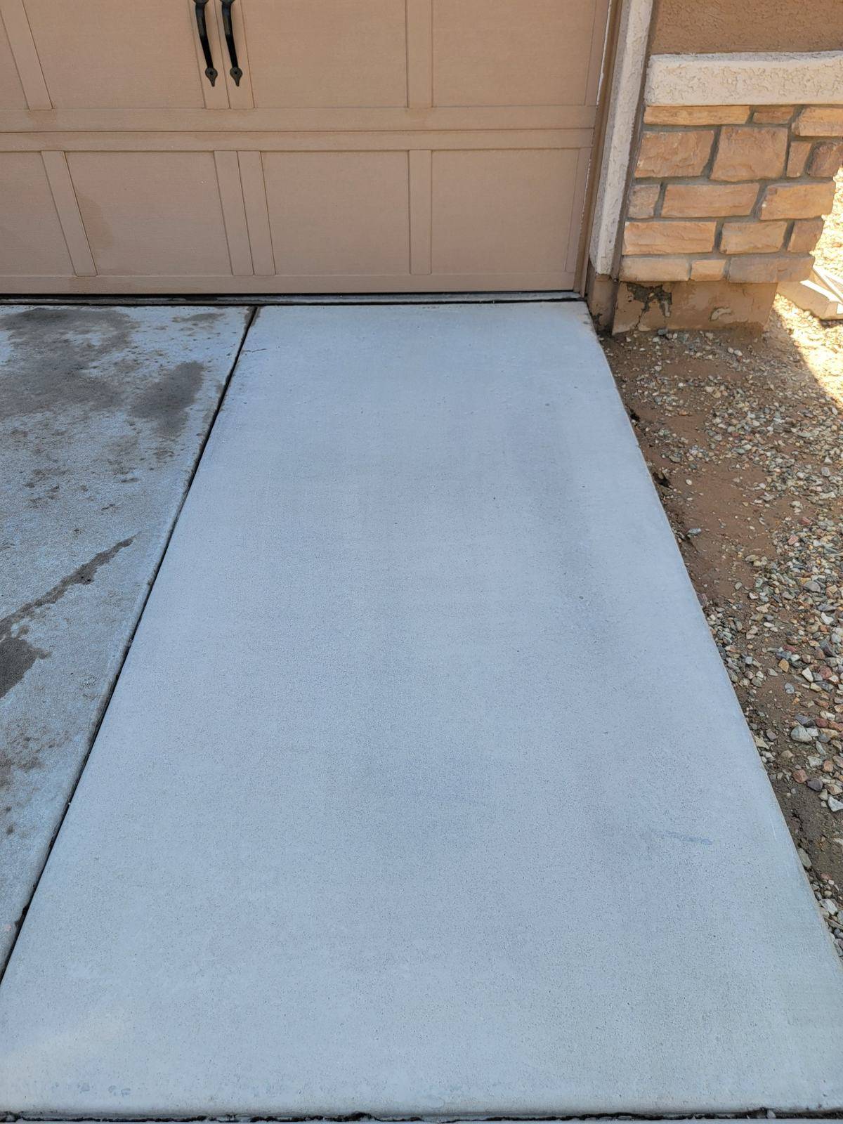 Concrete driveway section after cleaning beside the same untreated adjoining section