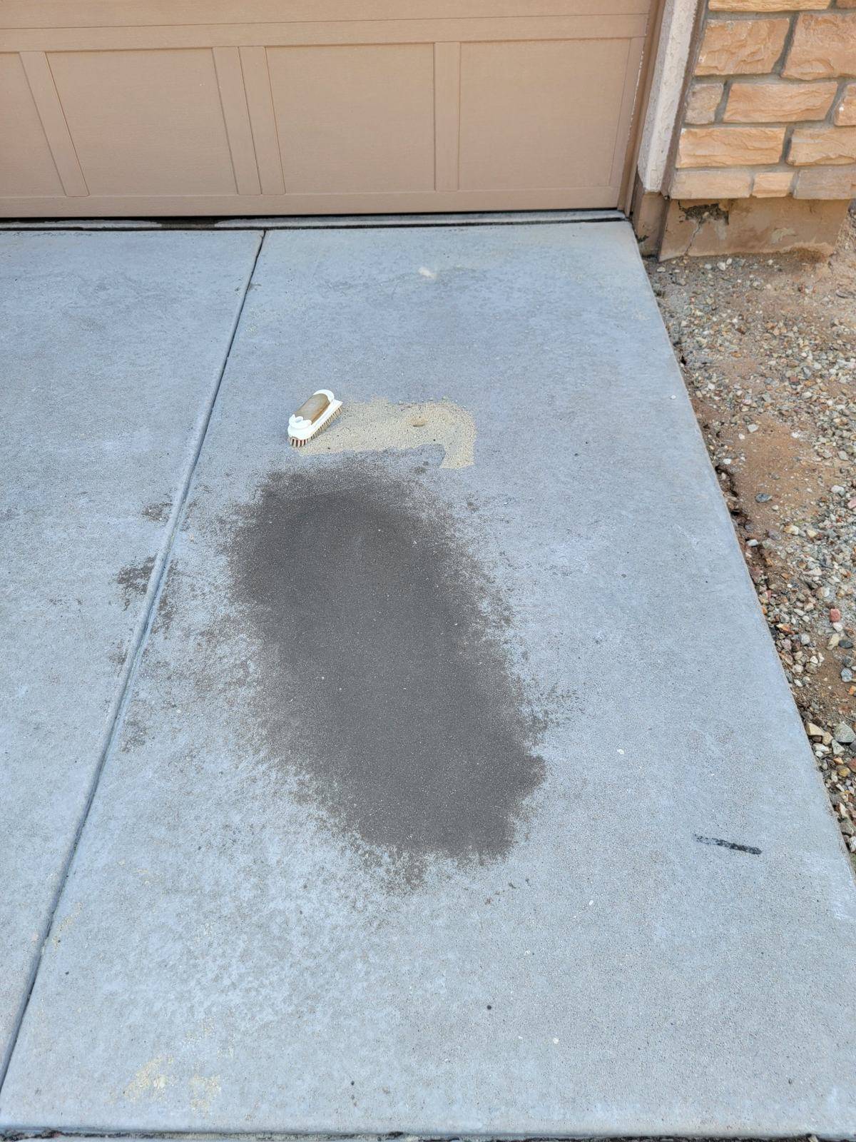 Concrete driveway with a dark stain before cleaning