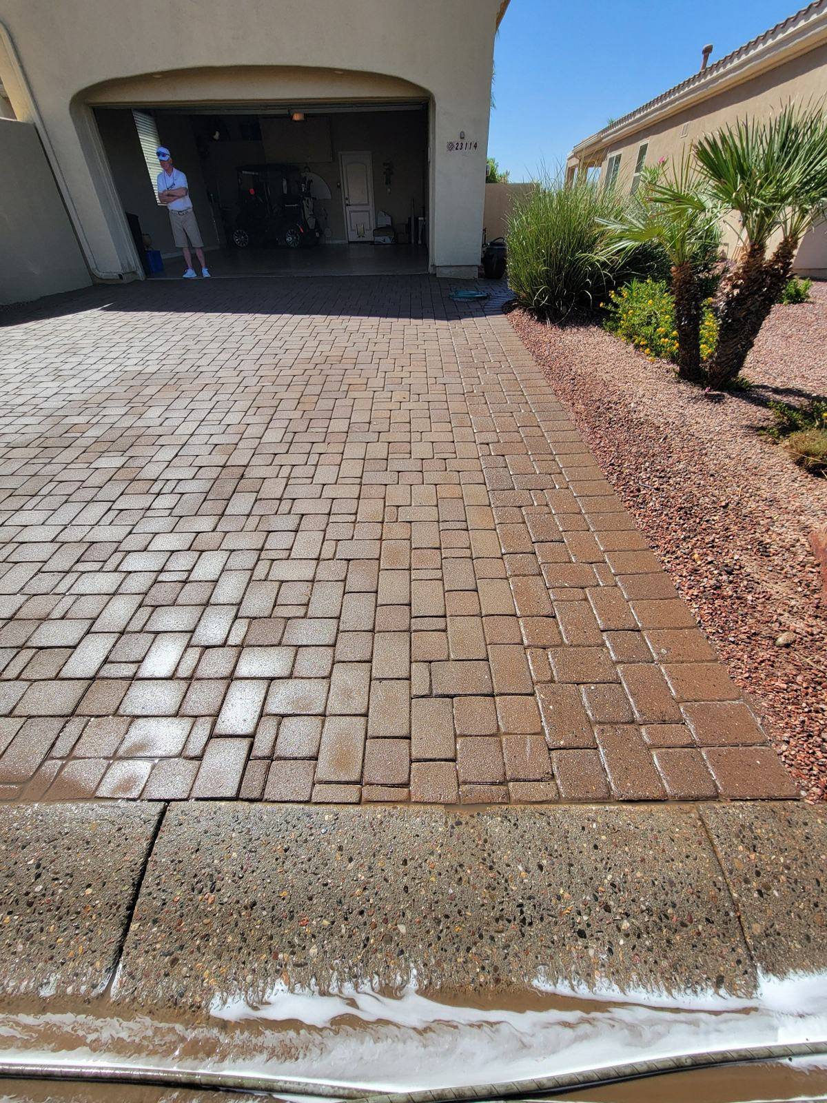 Wet paver driveway with rinse water during a Patriot cleaning project