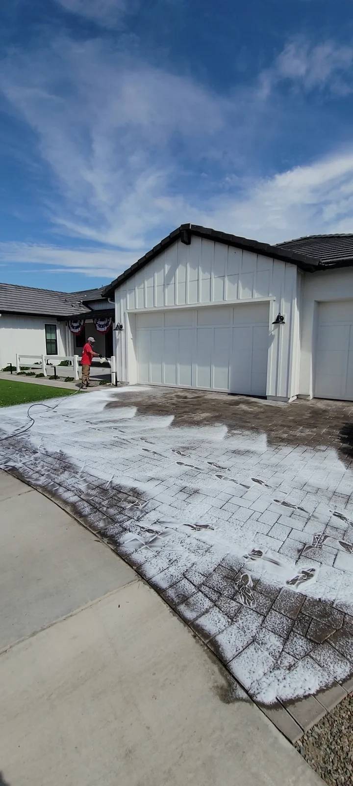 Patriot technician using a rotary surface cleaner on a paver driveway