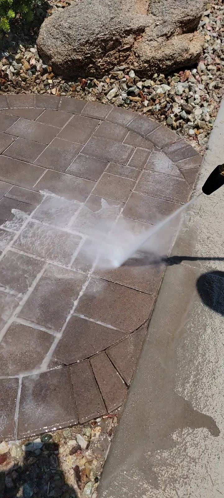 Sealer stripping in progress on a curved paver walkway